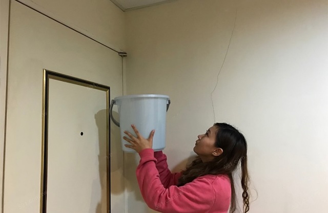 Hình ảnh hứng nước mưa khi mái nhà bị dột cho thấy điềm báo may mắn về tài lộc